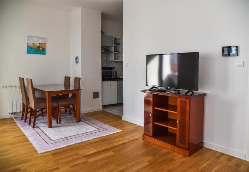 een woonkamer met een televisie en een eettafel bij Apartment Banja Luka, Park in Banja Luka