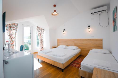 a hotel room with two beds and a window at Laguna Beach Club Bazaleti Lake in Dushetʼi