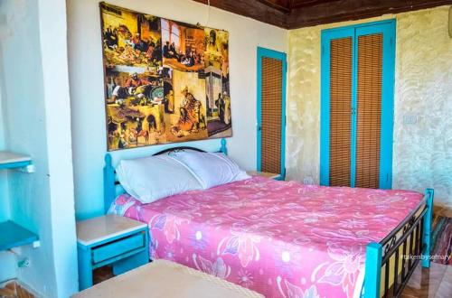 a bedroom with a pink bed and a painting on the wall at Kamariat Tunis Bay in Kafr ‘Amr