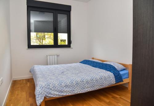 een slaapkamer met een bed en een raam bij Apartment Banja Luka, Park in Banja Luka