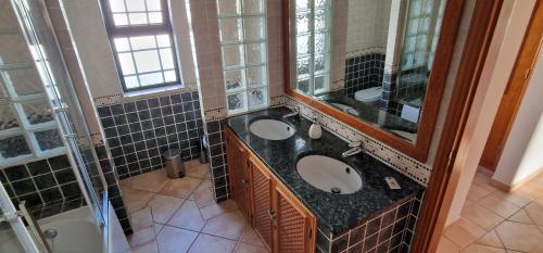 łazienka z 2 umywalkami i dużym lustrem w obiekcie Villa Pretty w mieście Almancil