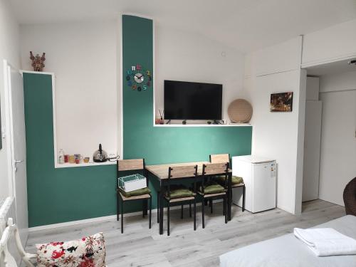 ボローニャにあるResidenza le Torriのテーブル、椅子、テレビが備わる客室です。
