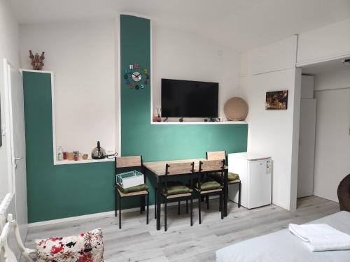 Una habitación con una mesa y sillas y un televisor. en Residenza le Torri, en Bolonia