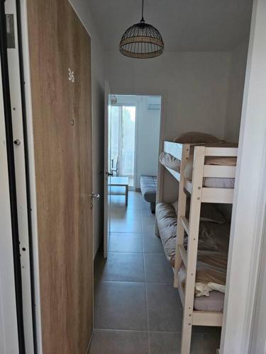 un couloir avec une chambre avec des lits superposés et une porte dans l'établissement Grande motte Studio cabine parking clim plage 500m, à La Grande Motte