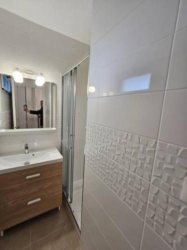 une salle de bain avec un lavabo, une douche et un miroir dans l'établissement Grande motte Studio cabine parking clim plage 500m, à La Grande Motte