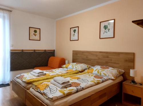 ein Schlafzimmer mit einem großen Bett und einem orangenen Stuhl in der Unterkunft Ubytování Na Vinici in Valtice