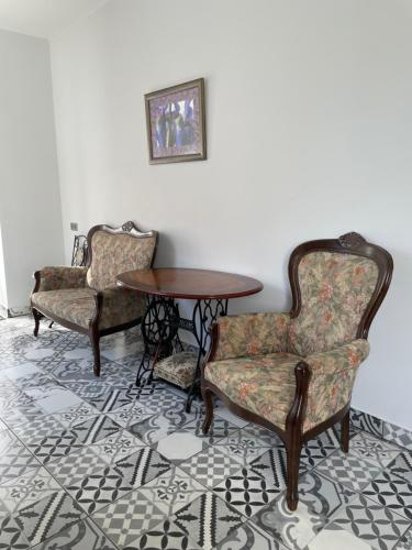 duas cadeiras e uma mesa num quarto em Cozy 1bedroom condo near Baltic sea em Salacgrīva