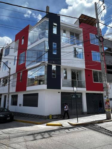 a man walks in front of a building at Hotel SOGU TOWER in Ayacucho