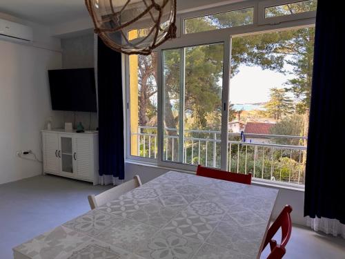 une salle à manger avec une table et une grande fenêtre dans l'établissement Beach Apartment, à Biograd na Moru