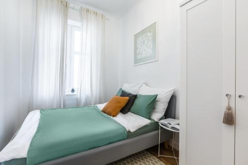 sypialnia z łóżkiem z zielonymi i białymi poduszkami w obiekcie Heart of Center w mieście Rzeszów