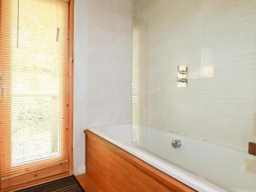 a white bath tub in a bathroom with a window at 7 Stonerush Valley in Looe