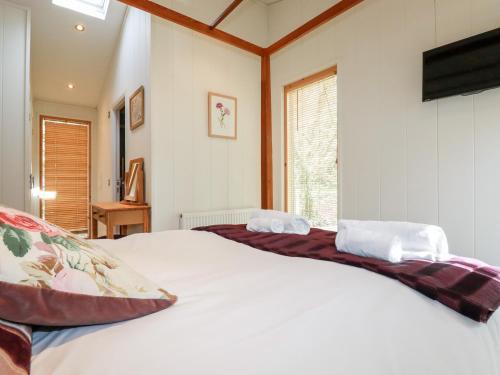 a bedroom with a large white bed and a window at 7 Stonerush Valley in Looe