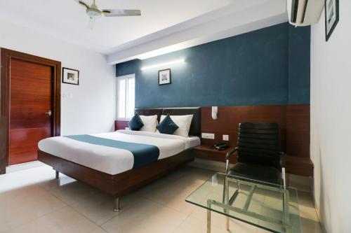 een slaapkamer met een bed en een stoel bij Hotel Stay Inn Maharani Peta in Alipur