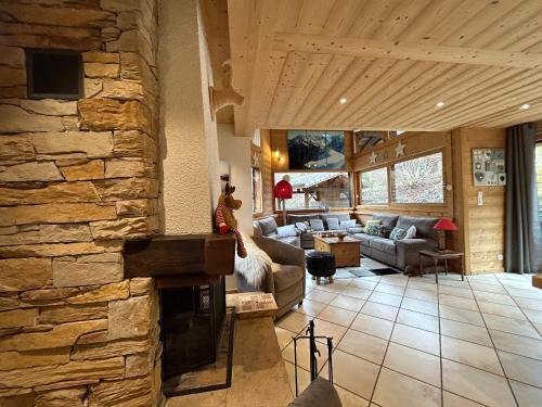 a living room with a stone fireplace in a house at Chalet Adonis - Montriond, Morzine, Avoriaz in Montriond