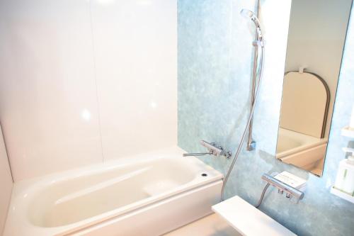 La salle de bains est pourvue d'une douche, d'une baignoire et d'un lavabo. dans l'établissement Esashi-gun - Cottage - Vacation STAY 38350v, à Pinneshiri