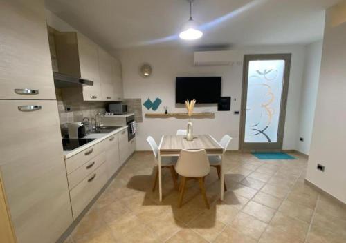 a kitchen and dining room with a table and chairs at [Loft Comodo ed Elegante] • Wi-Fi e Colazione in Sanluri
