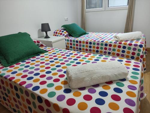 um quarto com 2 camas com lençóis de bolinhas em Piso en Cedeira em Cedeira