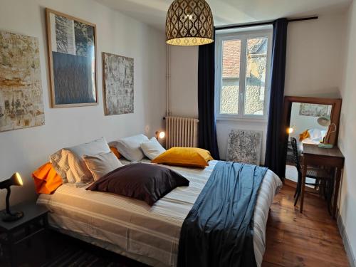 a bedroom with a large bed and a desk at Le Chat Botté Chambres et Table d'hôte sur réservation in Arthez-de-Béarn