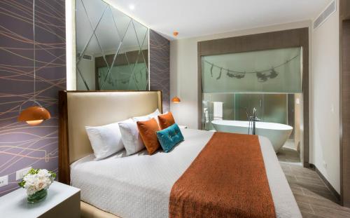 a hotel room with a bed and a bath tub at Nickelodeon Hotels & Resorts Punta Cana - Gourmet All Inclusive by Karisma in Punta Cana