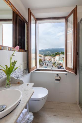 a bathroom with a toilet and a sink and a window at Sirolo Sea rooms in Sirolo