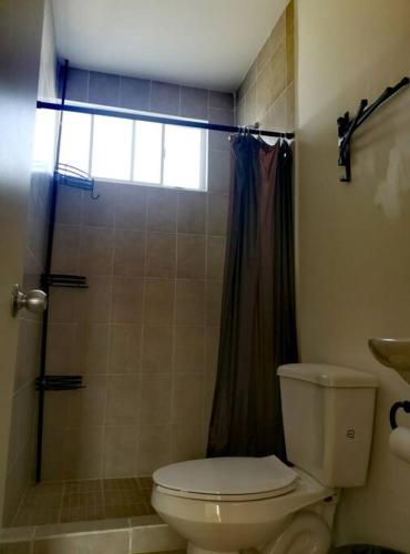 a bathroom with a toilet and a shower at Dafi´s House (Exclusivo con jardín) in Ayala