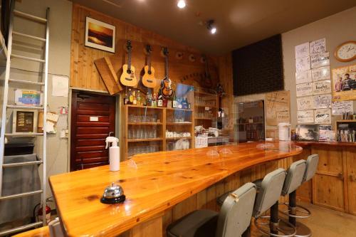 eine große Holzbar in einer Küche mit Stühlen in der Unterkunft Pension L&M - Vacation STAY 82545v in Fuchisaki