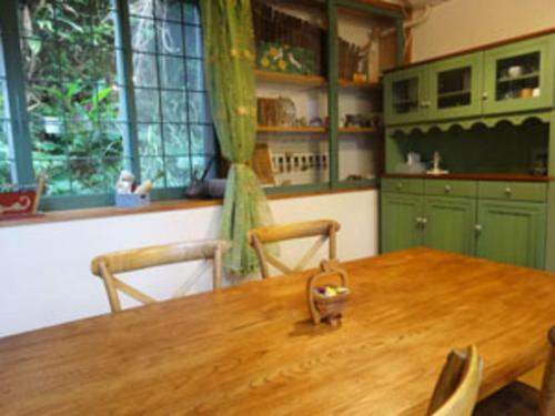 a kitchen with a wooden table and green cabinets at Amakara okinawa - Vacation STAY 85516v in Yohena
