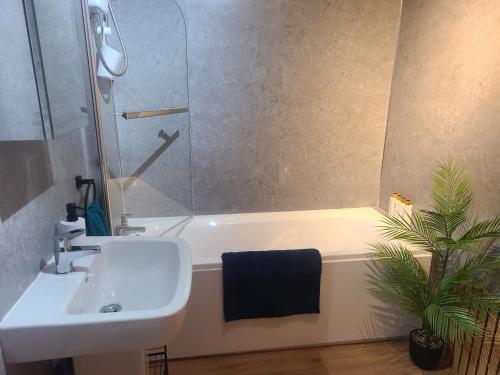 a bathroom with a sink and a shower and a tub at VALE VIEW APARTMENT, Prestatyn, North Wales - a smart and stylish, dog-friendly holiday let just a 5 min walk to beach & town! in Prestatyn