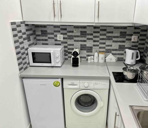 a kitchen with a washing machine and a microwave at ATH Luxury Central apartment in Athens