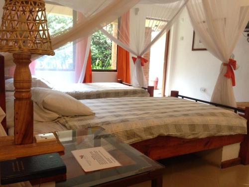 a bedroom with two beds and a glass table at Outpost Lodge in Arusha