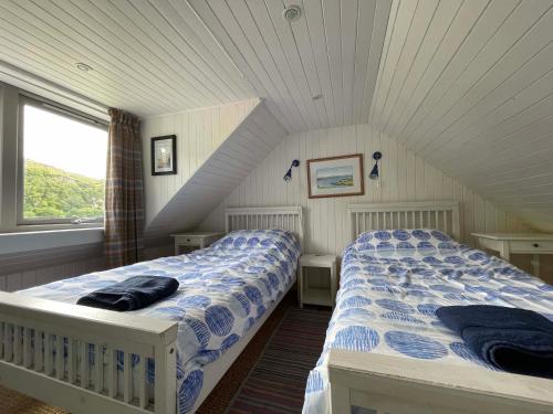a bedroom with two beds in a attic at Pier Cottage, Applecross in Applecross