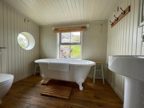 a bathroom with a tub and a window at Pier Cottage, Applecross in Applecross