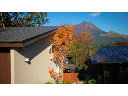 a house with a roof with a mountain in the background at Innterhill Tsubasa Yufuin - Vacation STAY 94230v in Yufuin