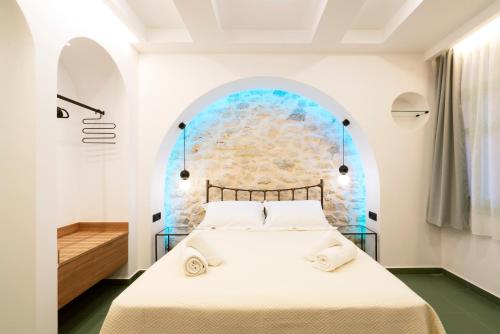 a bedroom with a white bed with an archway at Sartori Concept Hotel in Heraklio Town