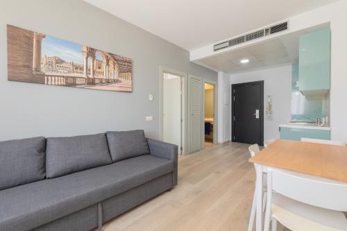 uma sala de estar com um sofá e uma mesa em Apartment with free parking and pool em Bormujos