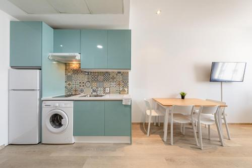 a kitchen with a table and a washing machine at Apartment with free parking and pool in Bormujos