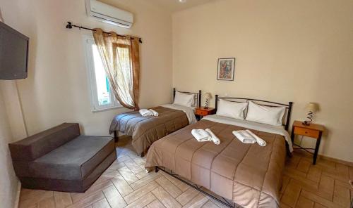 a room with two beds and a television in it at Central 9 Rooms in Ermoupoli