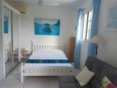 1 dormitorio con 1 cama y 1 sofá en Les Hauts de Terrasson, en Les Abymes