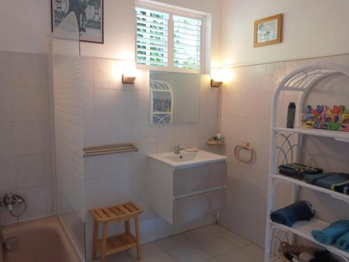 La salle de bains est pourvue d'un lavabo, d'une baignoire, de toilettes et d'une fenêtre. dans l'établissement Les Hauts de Terrasson, à Les Abymes