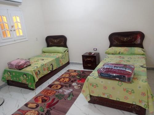 una camera con 2 letti e un tappeto di ابويحيى شارع ٦٦ a Marsa Alam