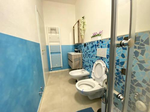 a blue bathroom with a toilet and a sink at Memory Suite con Wifi/Netflix in Bologna