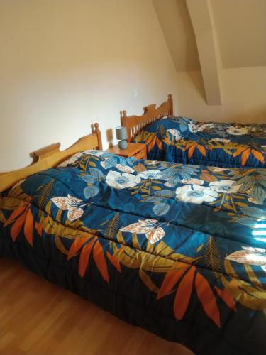 a bed with a colorful comforter in a bedroom at Les Chambres de Marvejols in Marvejols