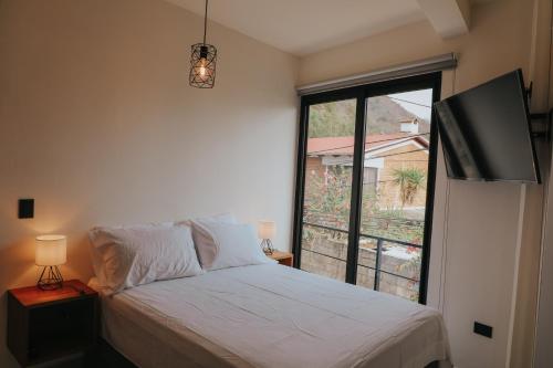 a bedroom with a bed and a large window at Lahos Apartament B in Panajachel