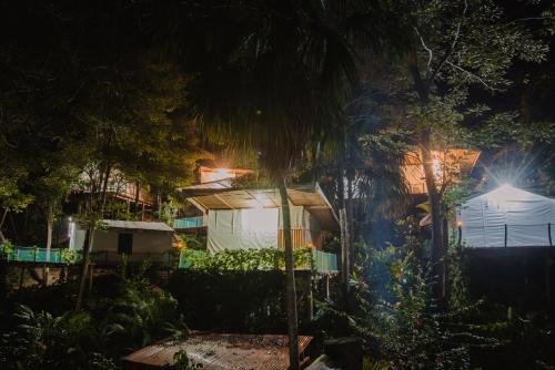 a night view of a house with a palm tree at Serrano Glamping in El Zaino