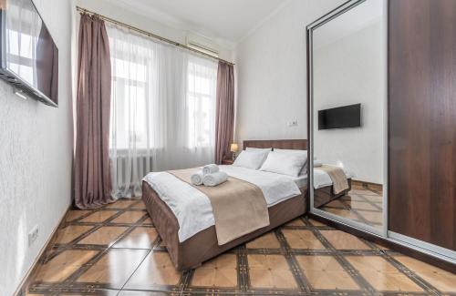 a bedroom with a bed and a large mirror at Khreschatyk. Maidan, Independence Square 2BR in Kyiv