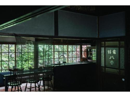 a dining room with tables and chairs and windows at Hyogo private house yogoto - Vacation STAY 00235v in Kamikawa