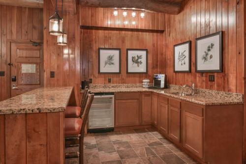 uma cozinha com painéis de madeira e um balcão com um lavatório em Slopeside Hotel by Seven Springs Resort em Champion