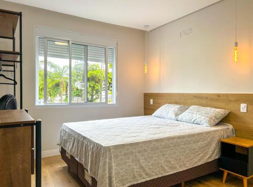 a bedroom with a bed and a window at Apto com Wi-Fi a beira-mar em Santo SP in Santos