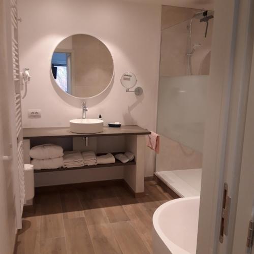 a bathroom with a sink and a mirror and a tub at B&B 't Hof van Spiere in Spiere