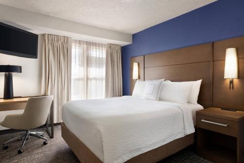 a hotel room with a large bed and a desk at Residence Inn by Marriott Roseville in Roseville